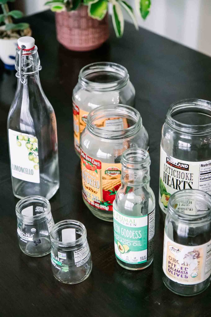 an assortment of empty glass food jars with labels on a wooden table