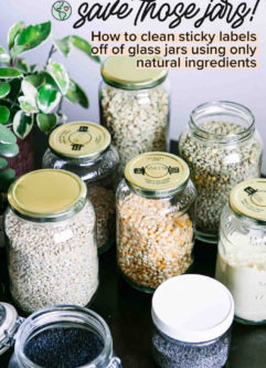 glass jars filled with bulk food items like lentils, dried corn, and grains on a wooden table with the words "save those jars! how to clean sticky labels off glass jars" in black writing