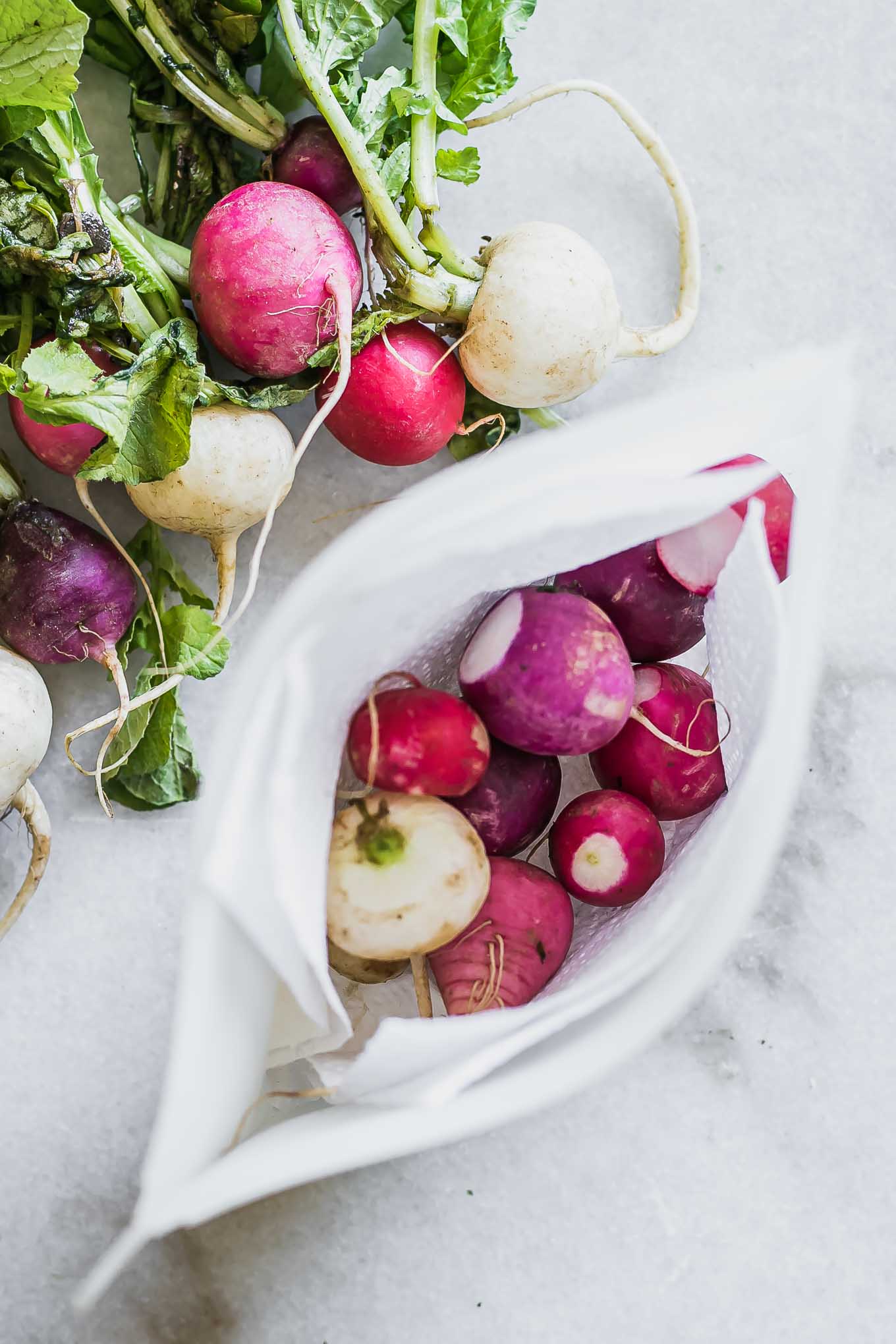 rainbow colored radishes on a white countertop