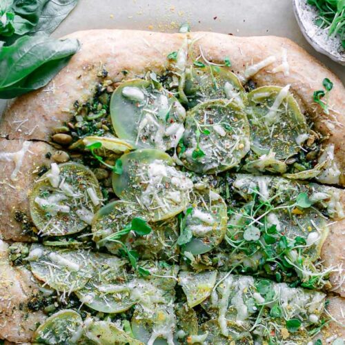 a pizza topped with micro greens and lemon zest